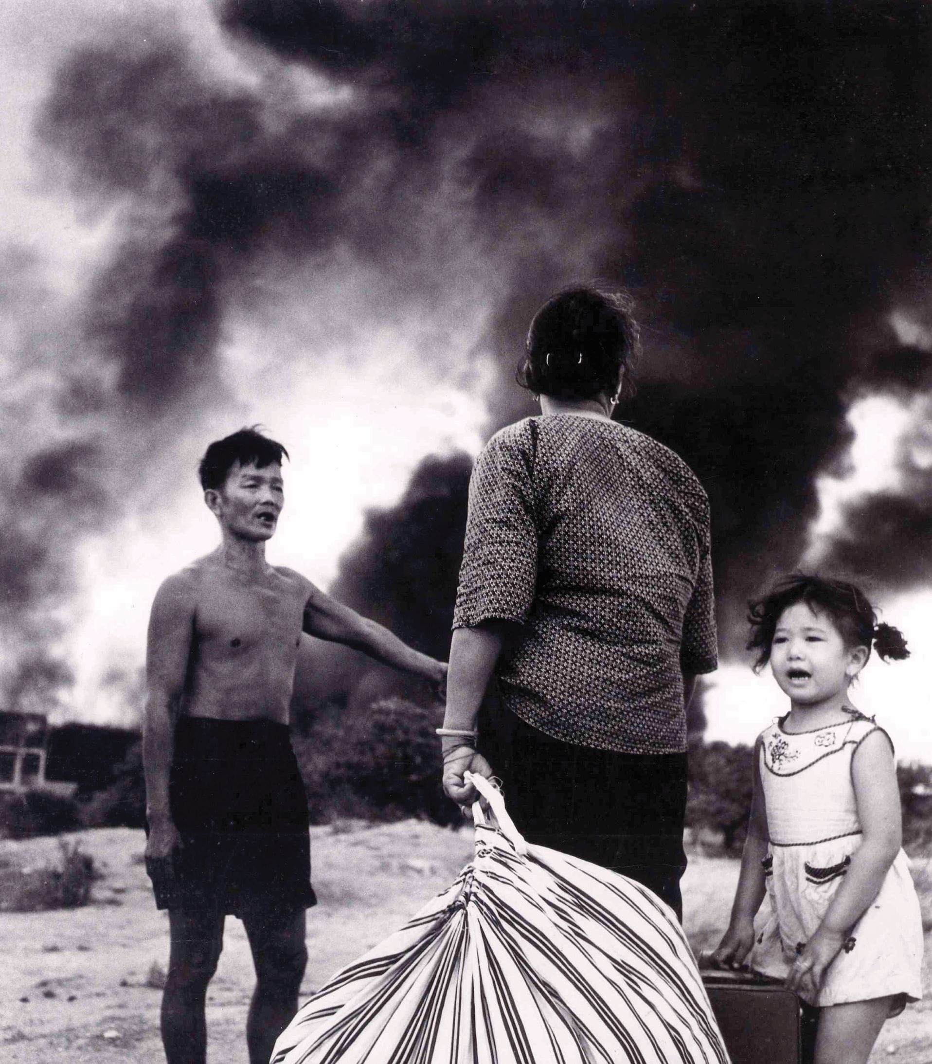 Fleeing the Bukit Ho Swee Fire on 25 May 1961. A family watch over their remaining belongings as the area is consumed by smoke. Courtesy of Sng Chye Kay.
